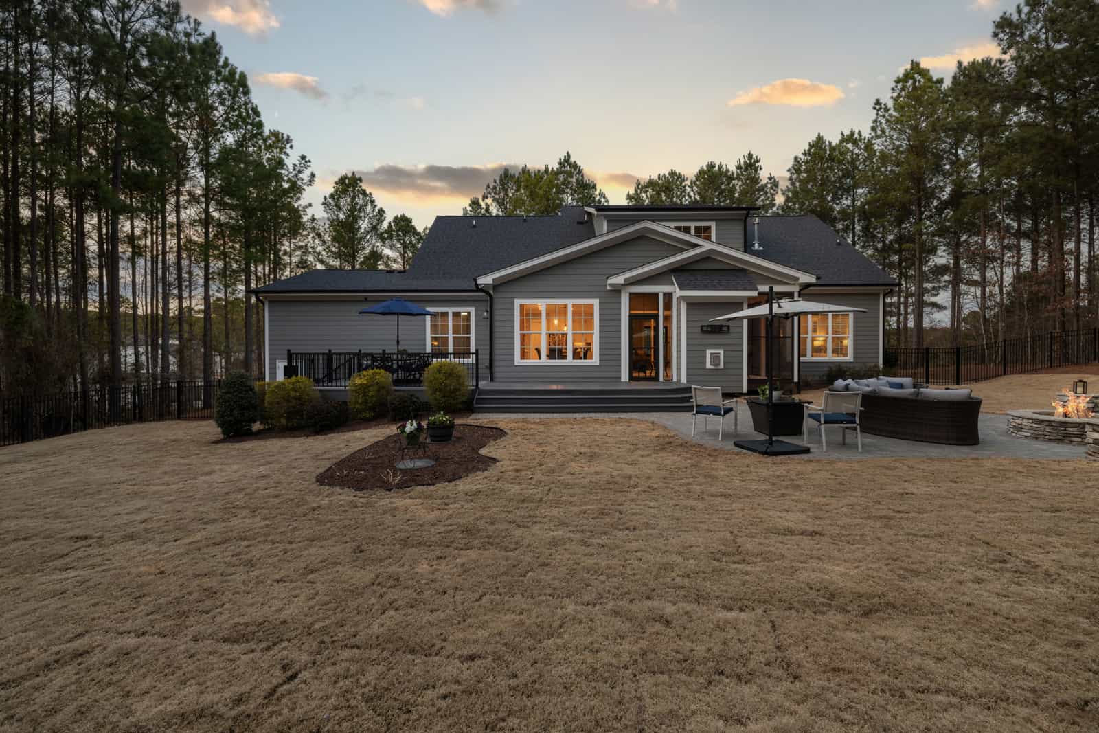 House with a wide lawn lit by a sunset