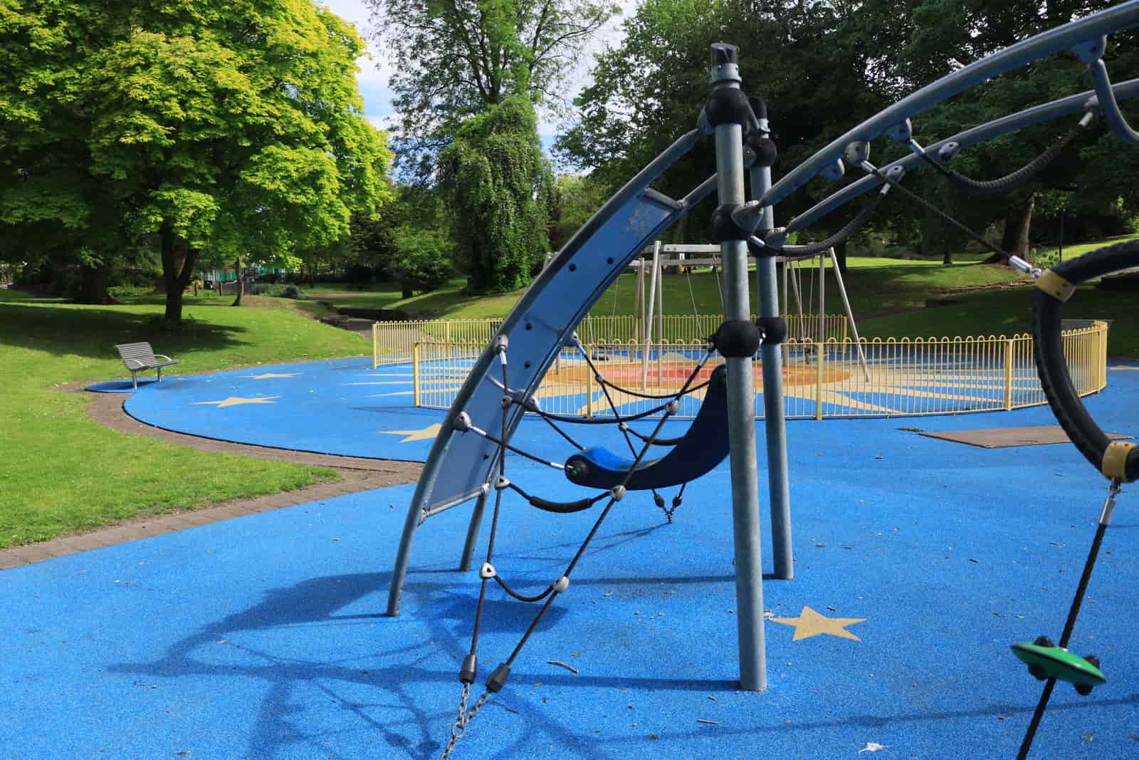 Playground climbing structures on blue poured-rubber flooring